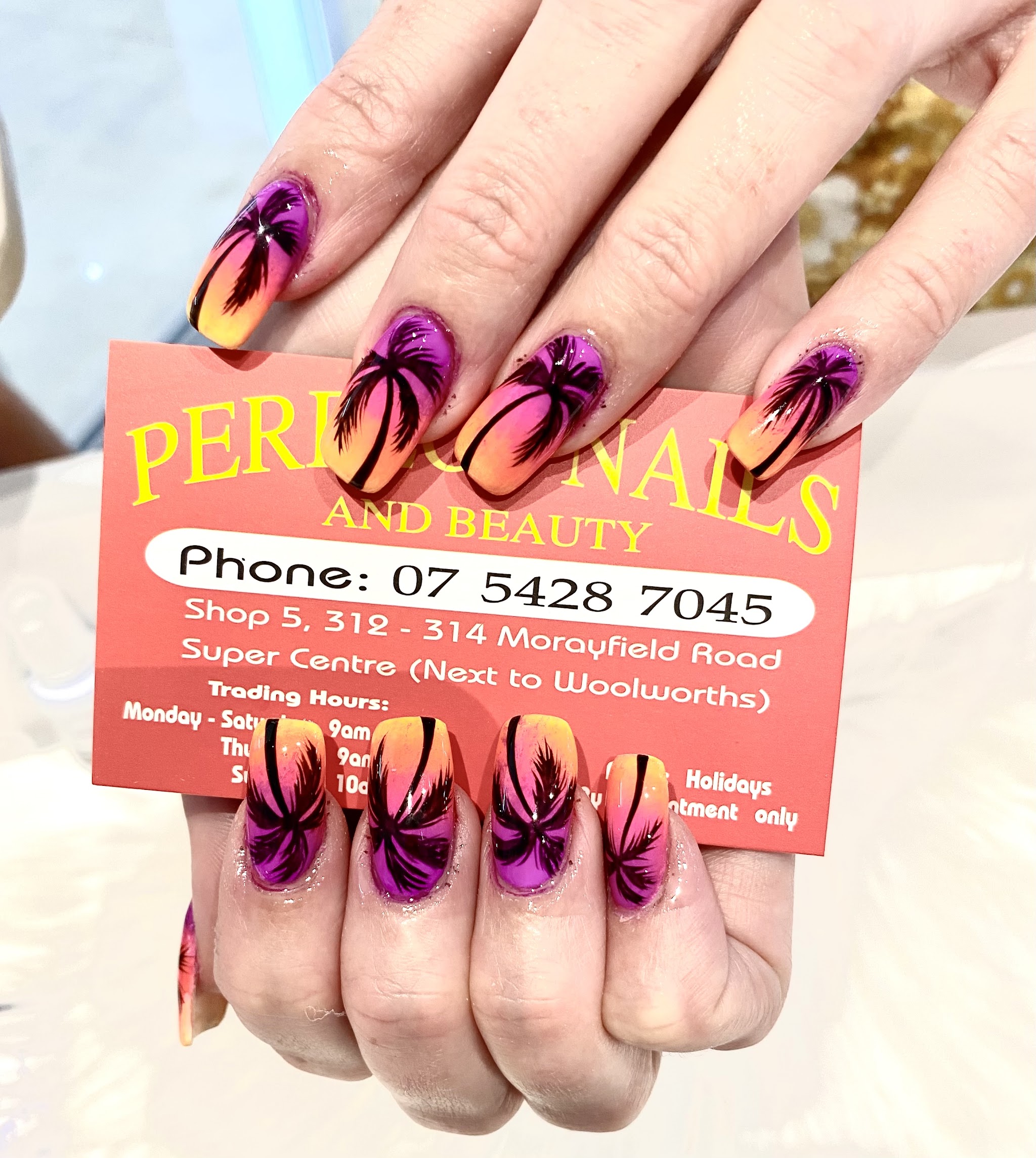Airbrushed sunset nails with black palm tree silhouettes
